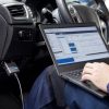 Laptop cu software de diagnoză și adaptor OBD conectat la bordul unui Ford, într-un service