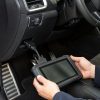 Tabletă de diagnoză conectată la mufa OBD sub bordul unei mașini pentru resetarea indicatorului de service